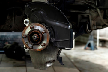 Canvas Print - A close-up on the front brake system of a car with hub on a lift in a vehicle repair workshop. Auto service industry.