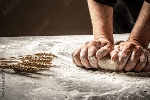 Cuadros en Lienzo Hands of baker kneading dough isolated on black background