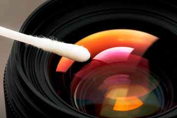 Poster - Gentle cleaning with a cotton swab camera Lens with a beautiful optical block close-up.