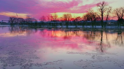 Wall Mural - Colorful Winter dawn reflected in tranquil river, this is the Fox River in Kaukauna, Wisconsin. It should be covered in thick ice, but it has thawed due to climate change.