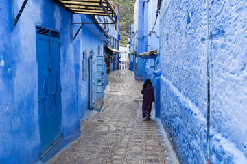 Traditional typical moroccan architectural details in Chefchaouen, Morocco, Africa Beautiful street of blue medina with blue walls and decorated with various objects (pots, jugs). A city with narrow, 