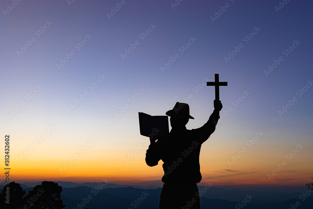 Human praying and holding christian cross for worshipping God at sunset ...