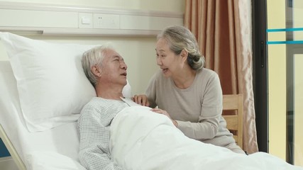 Canvas Print - asian senior woman visiting husband in hospital talking chatting kissing on forehead