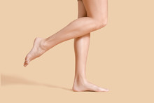 Legs Of Beautiful Young Woman On Color Background