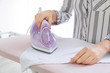 © Pixel-Shot - Woman ironing clean clothes at home, closeup