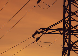 Electric pole with wires on a sunset background