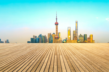 Empty wooden board square and cityscape at sunset in Shanghai