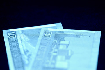 Wall Mural - Two Lithuanian banknotes on a dark surface. Ten and twenty litas close-up. Money background blue color toned