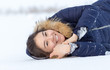 © donikz - Portrait of a beautiful girl in blue jackets on the background of snow. Outdoor winter portrait