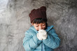 Kid feeling expression concept. Asian child girl wear winter coat jacket fells very cool during winter season. Small girl shiver in cold weather headwear.