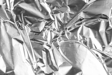 Close up of aluminium foil crumpled. Silver aluminium foil texture background. Abstract metallic paper pattern. Texture of crumpled aluminum kitchen foil. Silver abstract background