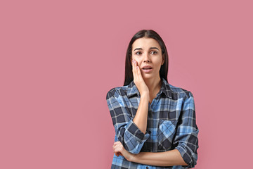 Sticker - Portrait of worried young woman on color background