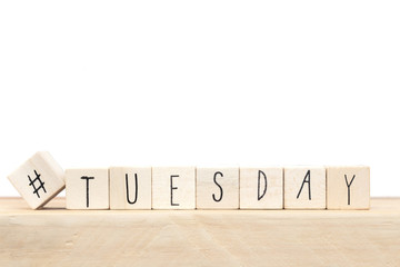 Wooden cubes with a hashtag and the word Tuesday, social media concept near white background