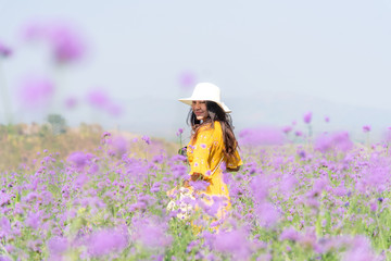 Traveler or tourism Asian women standing and chill  in the purple  verbena flower field in vacations time.  People  freedom and relax in the spring  meadow.  Lifestyle Concept