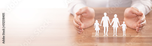 Cuadros en Lienzo Family care concept. Hands with paper silhouette on table.