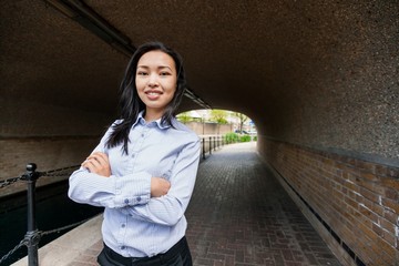 Wall Mural - Portrait of confident businesswoman standing arms crossed under bridge