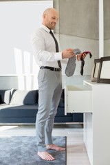 Full length side view of businessman selecting socks at home