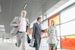© MDBPIXS - Businesspeople walking while male colleague running in railroad station