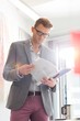 © MDBPIXS - Businessman reading documents in creative office