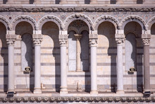 Facade Of Pisa Cathedral Close-up, With Arcades And Columns. Architectural Details, Carving And Decorating. Detail Of The Facade. Pisa, Italy.