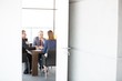 © moodboard - Businessmen and businesswoman in board room seen through open door at office