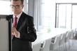 © moodboard - Mature businessman writing on whiteboard in board room