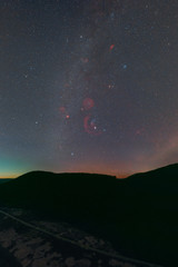 Wall Mural - Winter night sky including Barnard’s Loop, the Orion Nebula, the Flame Nebula, the Rosette Nebula, the California Nebula, and the Pleiades as seen from the Palatinate Forest in Germany.