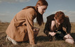 © Sergey Filimonov/Stocksy - Twins examining ground in field