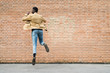 © Garage Island Crew/Stocksy - Cool man jumping against a wall
