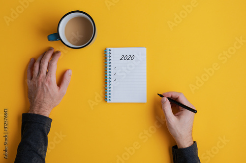 Cuadros en Lienzo Top view of a man writing down plans or resolutions for the year 2020