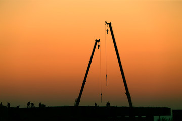 Wall Mural - A silhouette of a crane working at a construction site