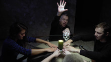 A Session Of Spiritualism Group Of People Sitting At A Round Table Holding Hands