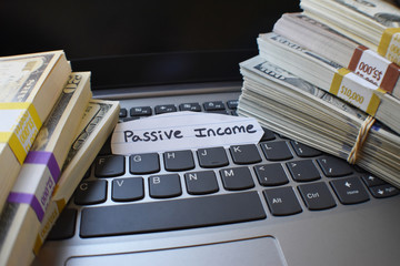 Wall Mural - Passive Income Concept With Stacks Of Money On Laptop Keyboard 