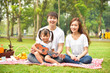 © tuastockphoto - Portrait of happy Asian family, parents and daughter enjoying picnic meal in garden. Asian, Asian family, picnic, love, relationship, outdoors meal, park, family activities or happy garden concept