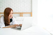 © tuastockphoto - Beautiful Asian woman using laptop n bed after wake up for checking email and social media, Asian family and technology concept