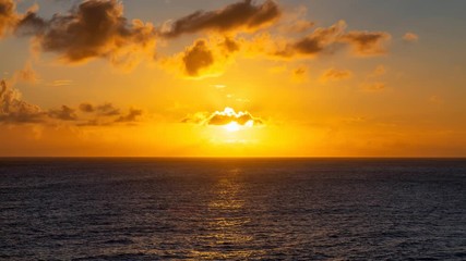 Wall Mural - Cinemagraph, Seamless loop Animation. Dramatic View of a cloudscape during a dark and colorful Orange sunset. Taken in the Tropics of Caribbean Sea in Barbados.