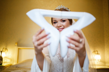 Wall Mural - bride puts on white shoes on the wedding day