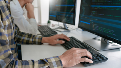 Wall Mural - young startup programmers sitting at desks working on computers screen for developing programming an