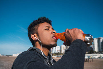 Athletic man drinking something after training.