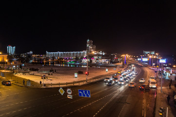 Wall Mural - Christmas night neon glowing cityscape. Buildings with decorations and lamps. Minsk Belarus. December 31 2019