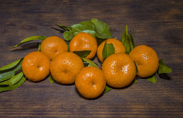 Tangerines with leaves on a black wooden table