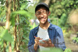 © Heru - Happy of smiling young Asian farmer male holding the notebook on green garden