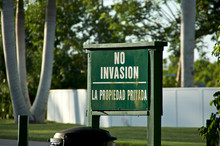 An Old Green Painted Wooden Sign Written In Spanish "no Invasion, La Propiedad Privada" Translates To  "No Trespassing, Private Property. In Naples Florida.