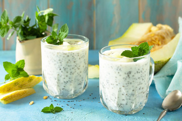 Poster - Healthy Pudding in a glass with Chia and melon and on blue stone  table. Healthy breakfast, vitamin snack, diet and healthy eating.