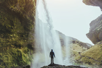 Wall Mural - outdoor adventure, person standing near waterfall Kvernufoss in Iceland, nature landscape