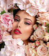 © Valua Vitaly - Beautiful white girl with flowers. Stunning brunette girl with big bouquet flowers of roses. Closeup face of young beautiful woman with a healthy clean skin. Pretty woman with bright makeup