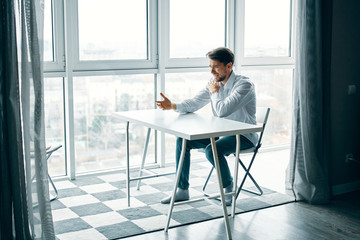 Wall Mural - businessman sitting on chair and looking at camera