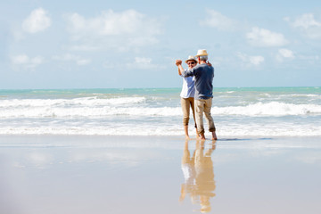 Wall Mural - Happy asian couple dancing on the beach enjoy  life