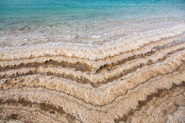 View of Dead Sea coastline at sunset time in Jordan. Salt crystals at sunset. Dead sea landscape with minehral structures.