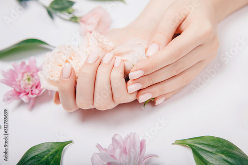 Vászonkép Beautiful stylish trendy female pink manicure with flower on background, top view